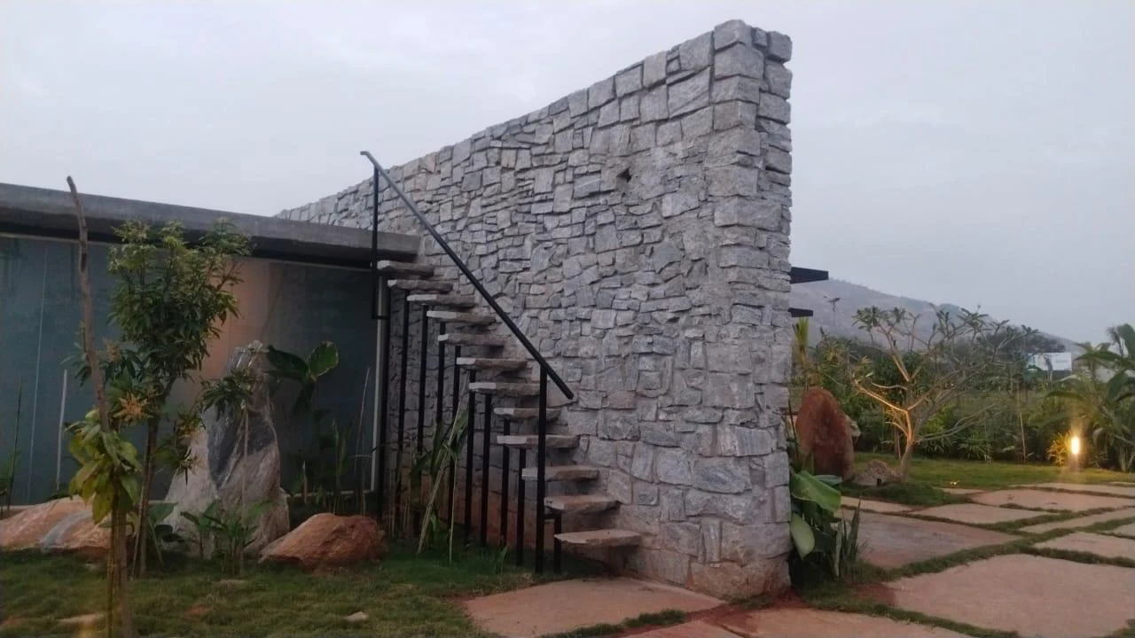Stone wall, exterior staircase and landscaped planting