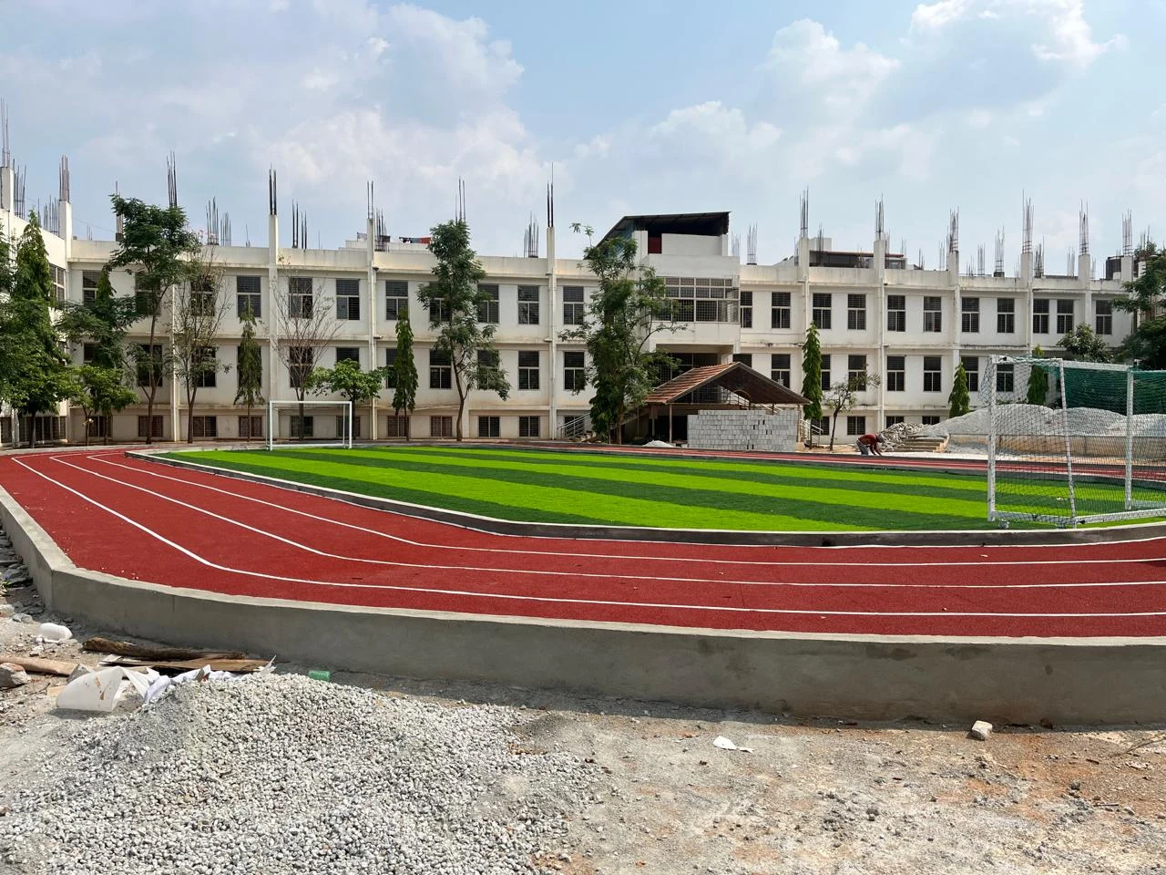 Campus buildings alongside a running track and sports field