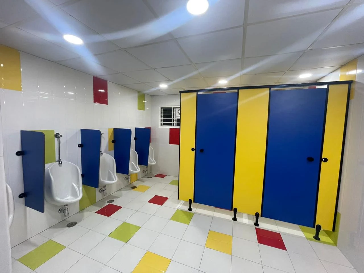 Washroom with colourful cubicle partitions and tiled finishes
