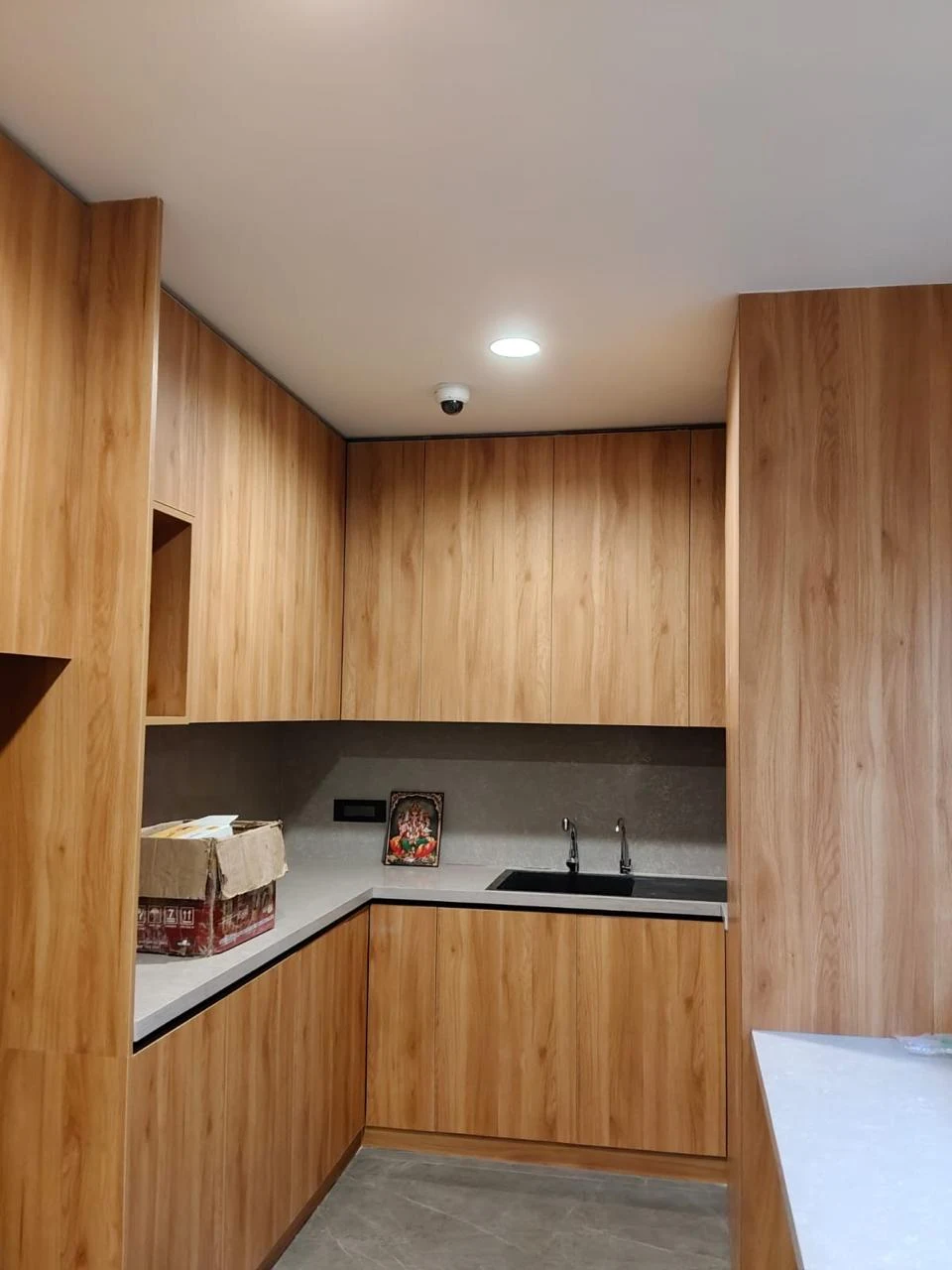 Kitchen with timber cabinetry, dark worktop and integrated appliances