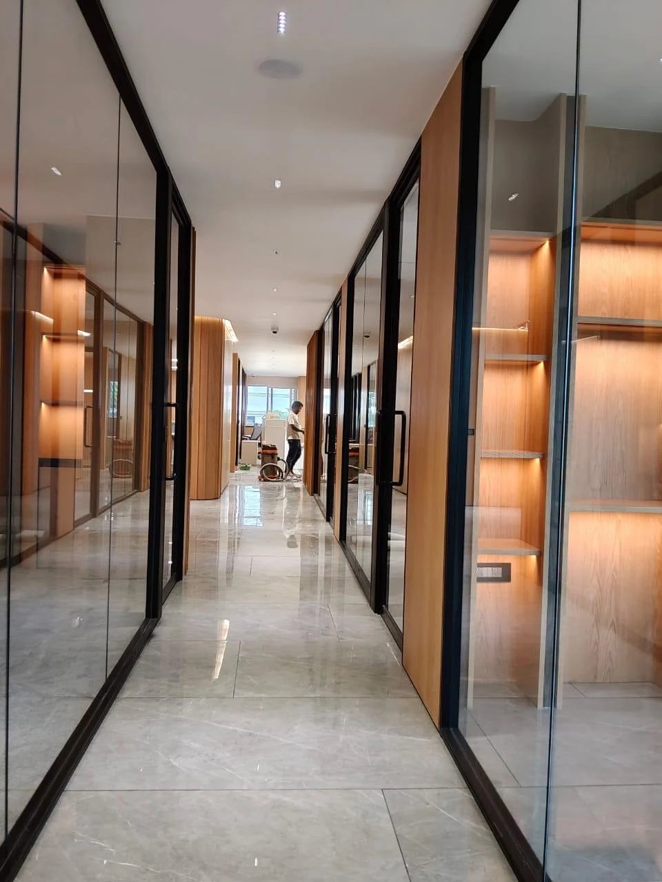 Corridor with timber finishes, glass partitions and warm lighting