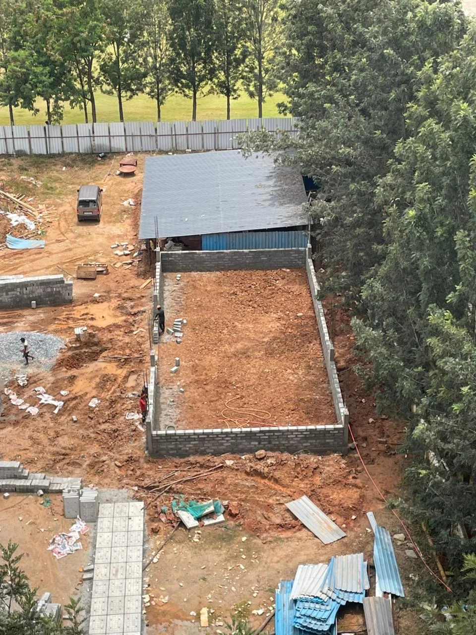 Aerial view of a site with a partially built structure and cleared ground