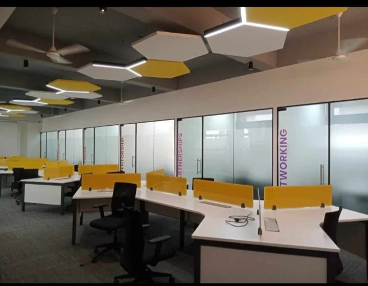 Office workspace with yellow seating and geometric ceiling details